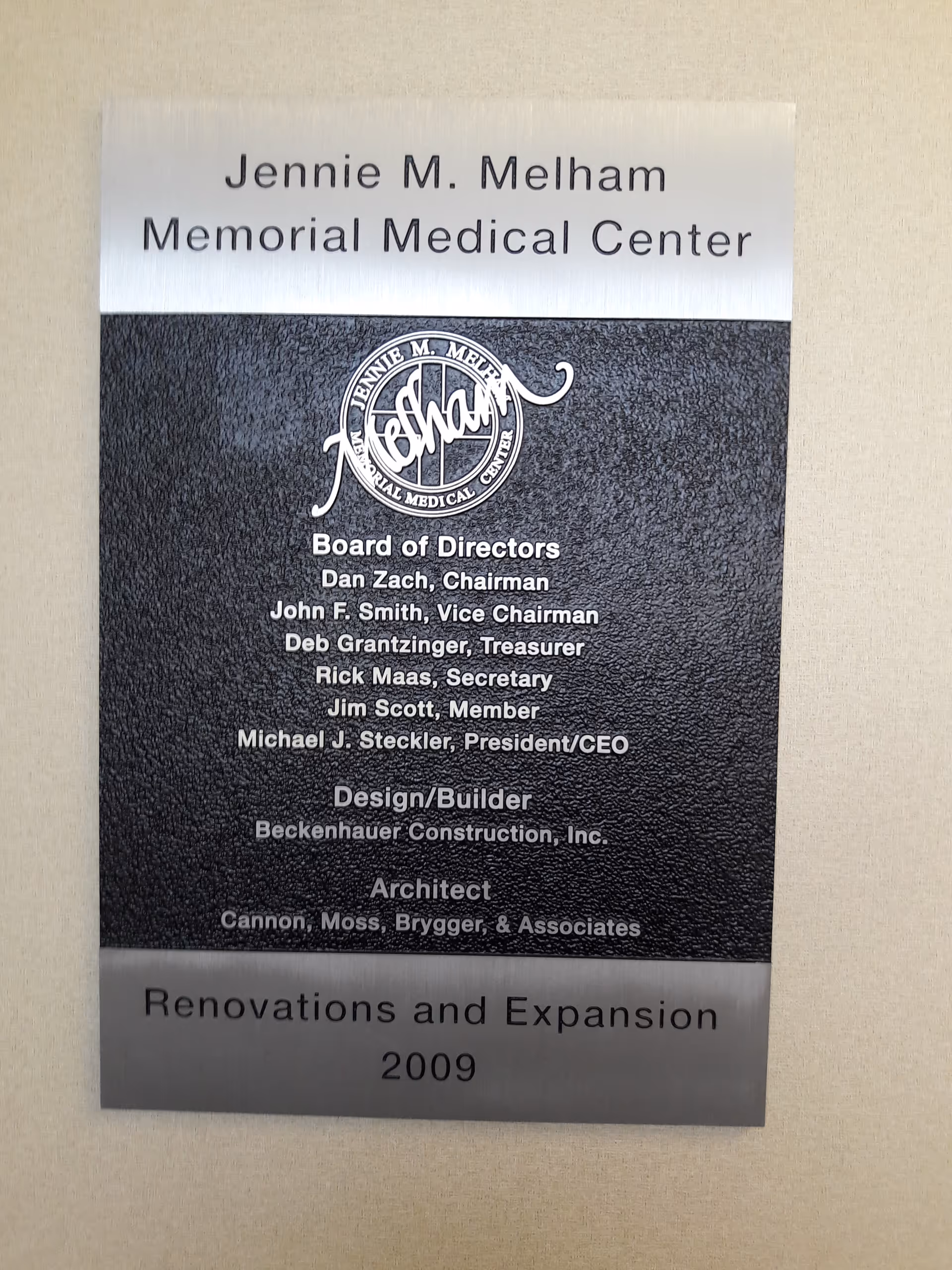 Metal plaque on wall lists board of directors for Jennie M. Melham Memorial Medical Center.