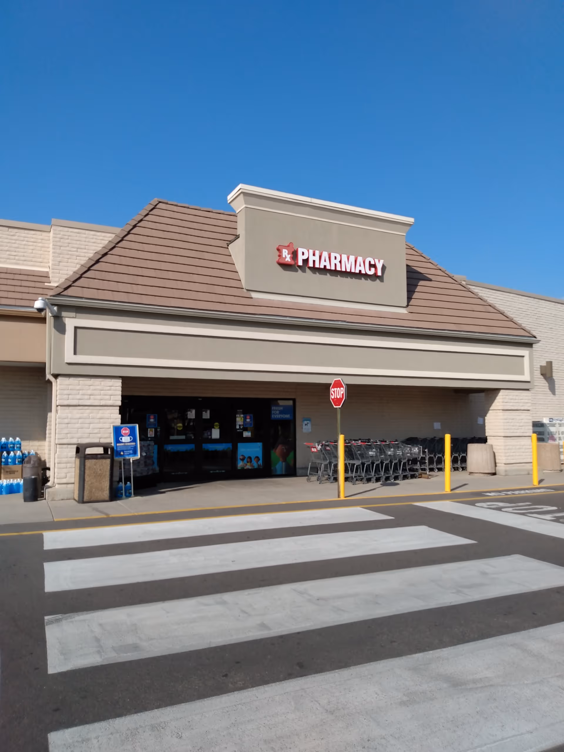 Front view of King Soopers Pharmacy storefront with crosswalk and carts