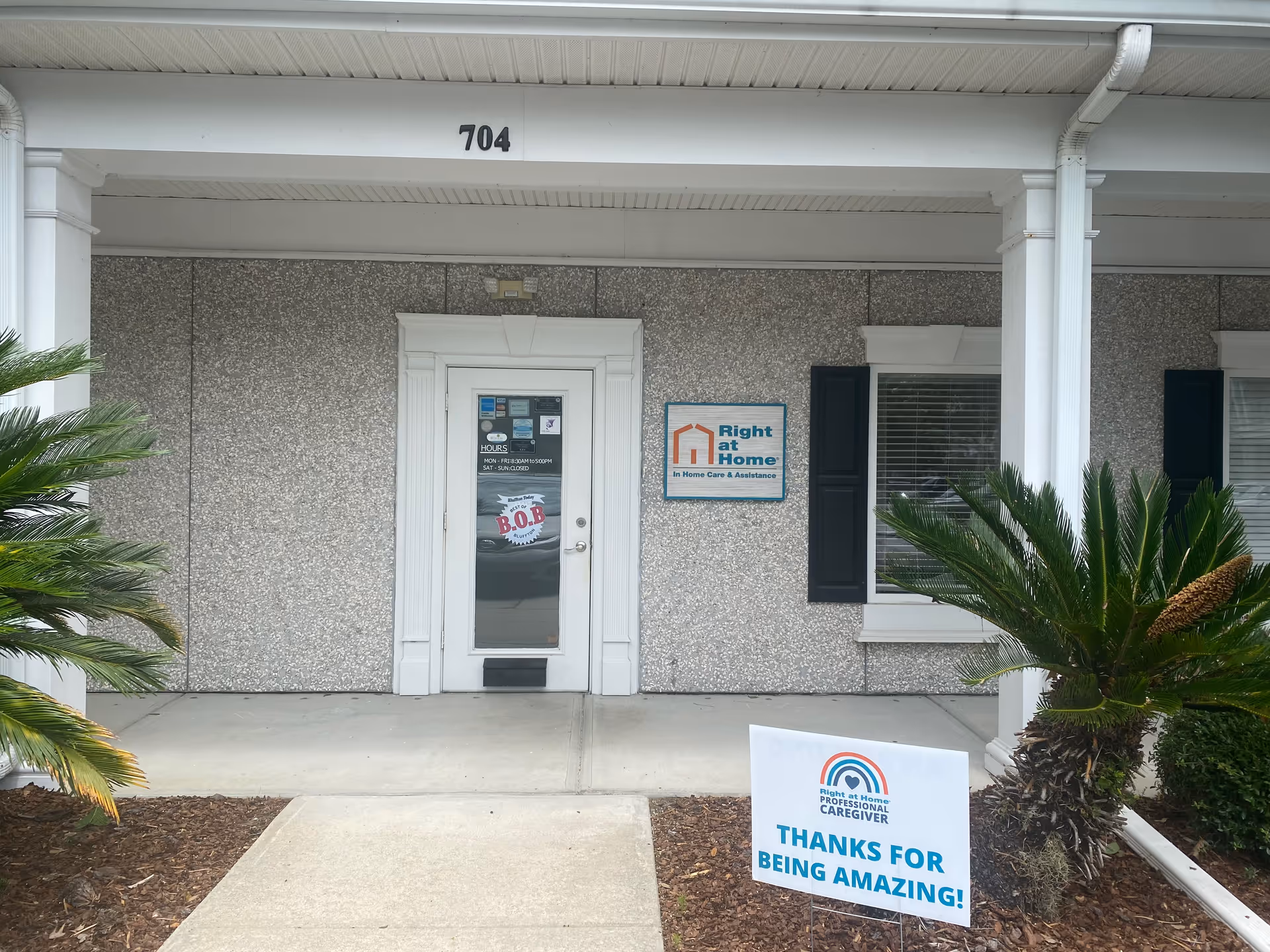 Front entrance of Right at Home senior care building with sign and plants.