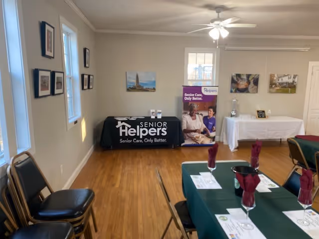 Event setup in a Senior Helpers room with banners and dining tables.