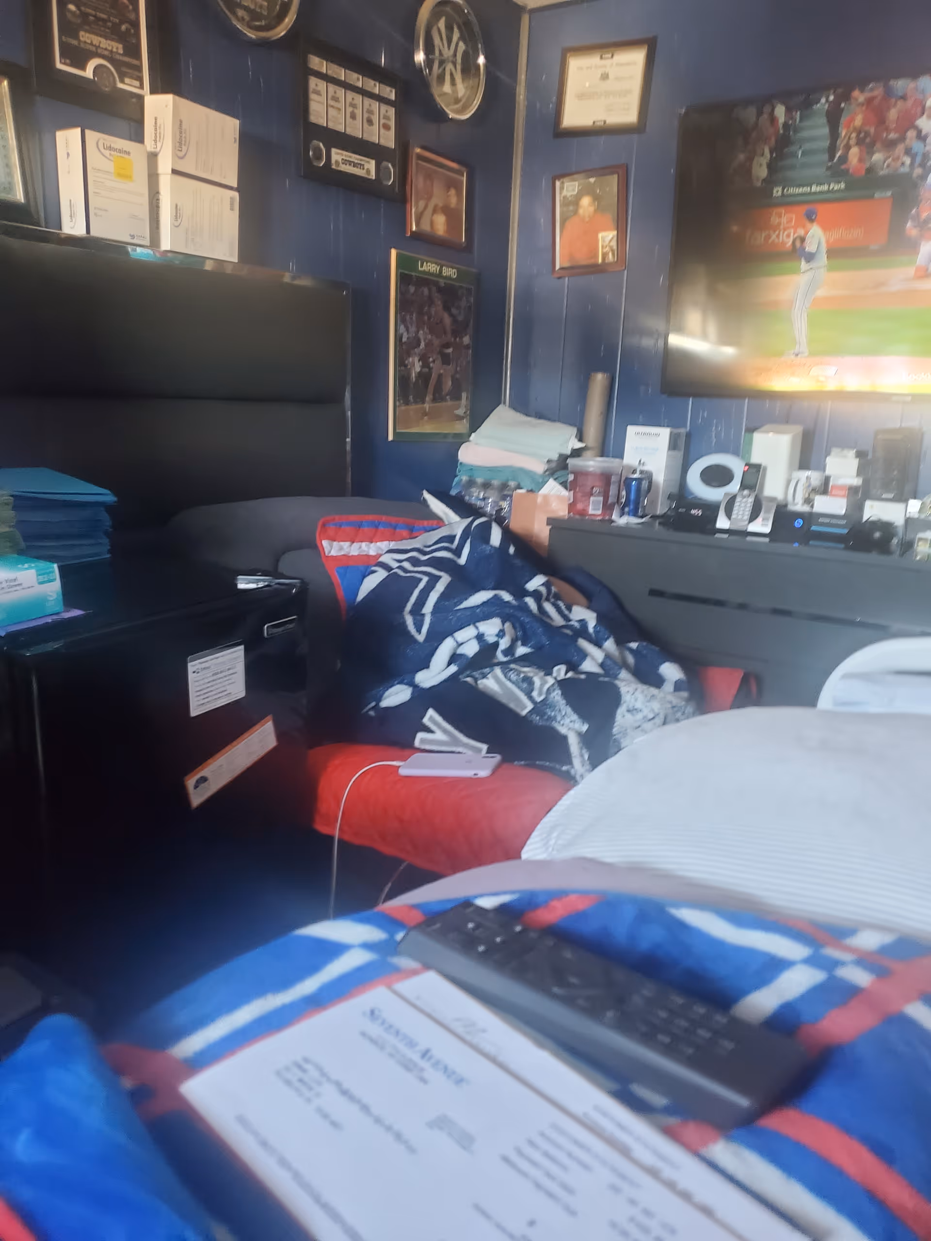 Cozy, cluttered bedroom in a senior home with a TV and blue walls.