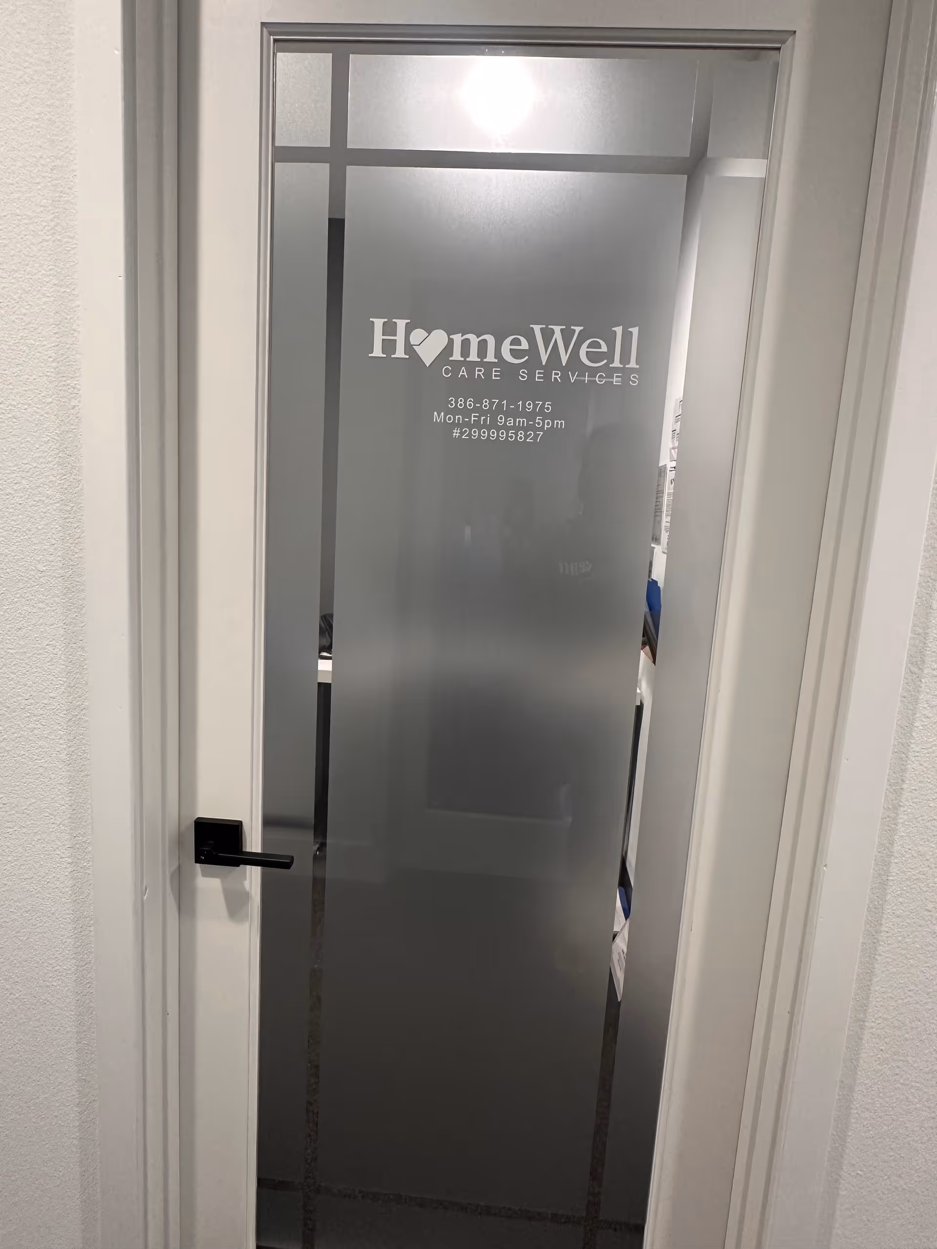 Frosted glass door labeled HomeWell Care Services with contact details.