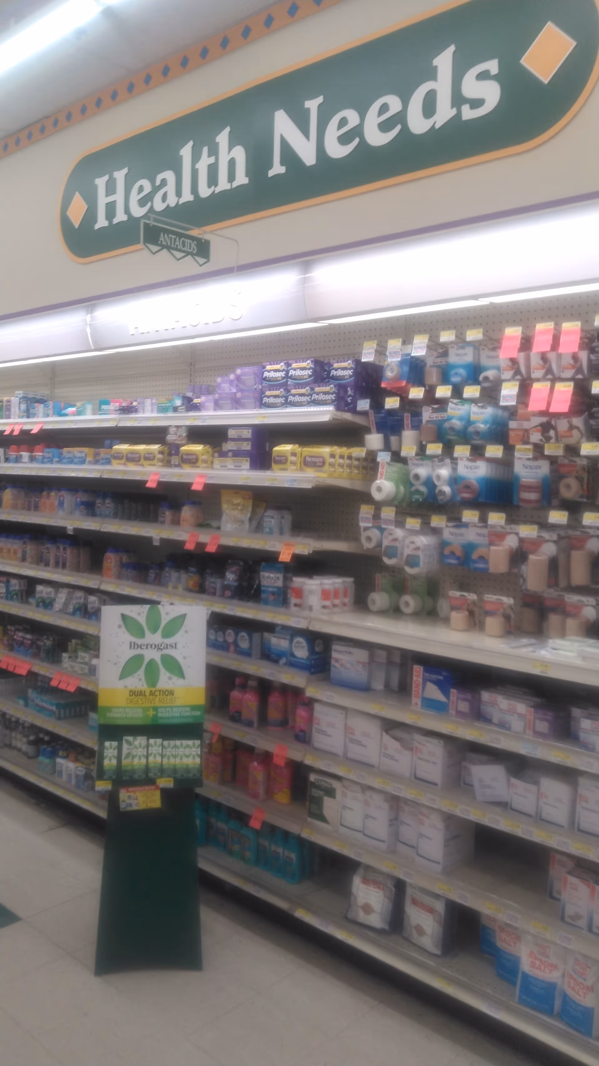Interior of Discount Drug Mart with health products on shelves and a Health Needs sign.