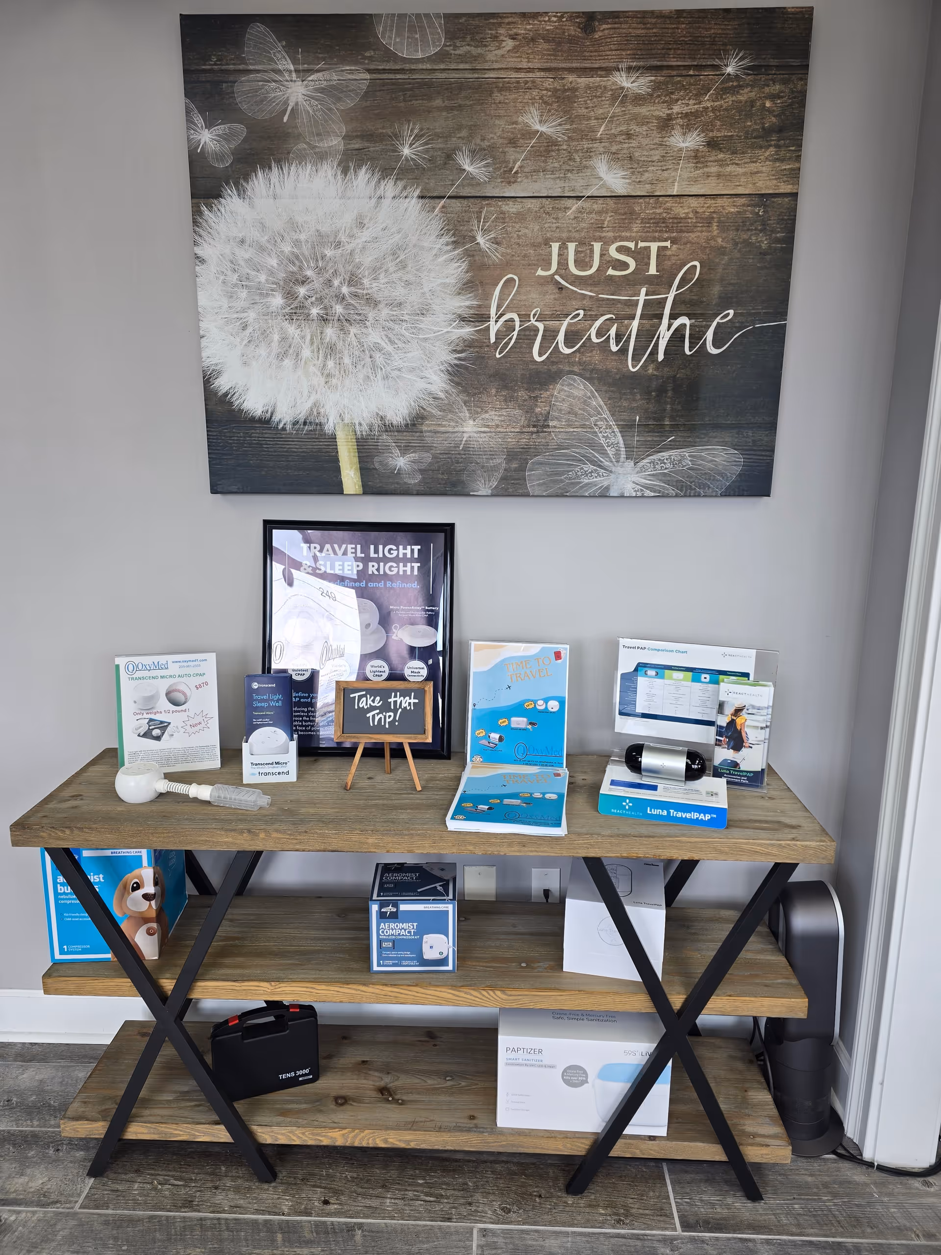 A wooden display table with CPAP devices and brochures in a clinic-like interior.