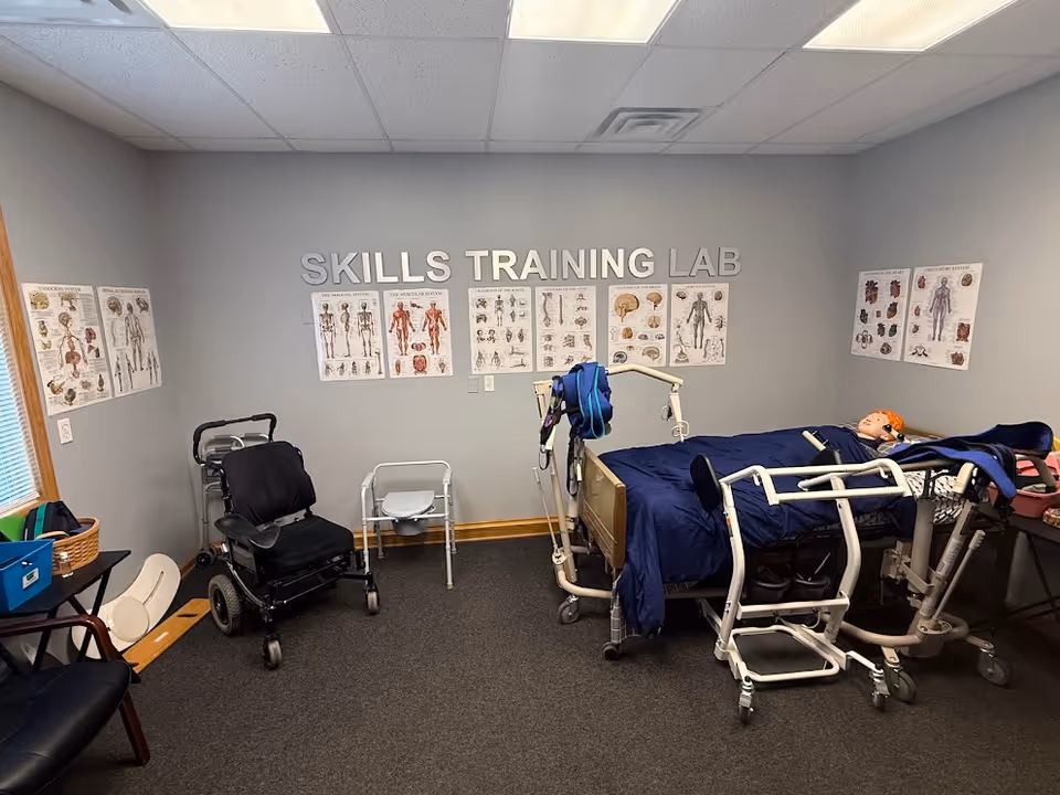 A Skills Training Lab with hospital bed, charts, and medical equipment in a bright room.