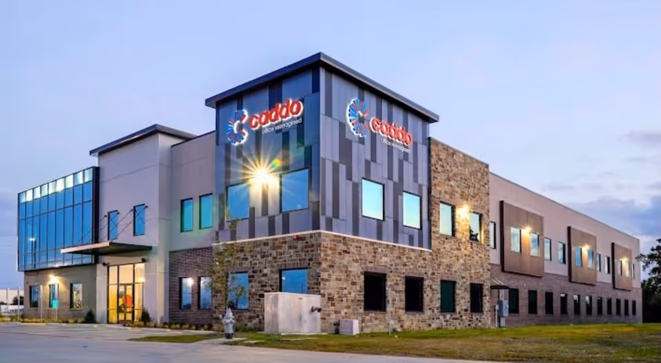 Two-story modern senior living facility exterior with stone accents and blue-gray panels