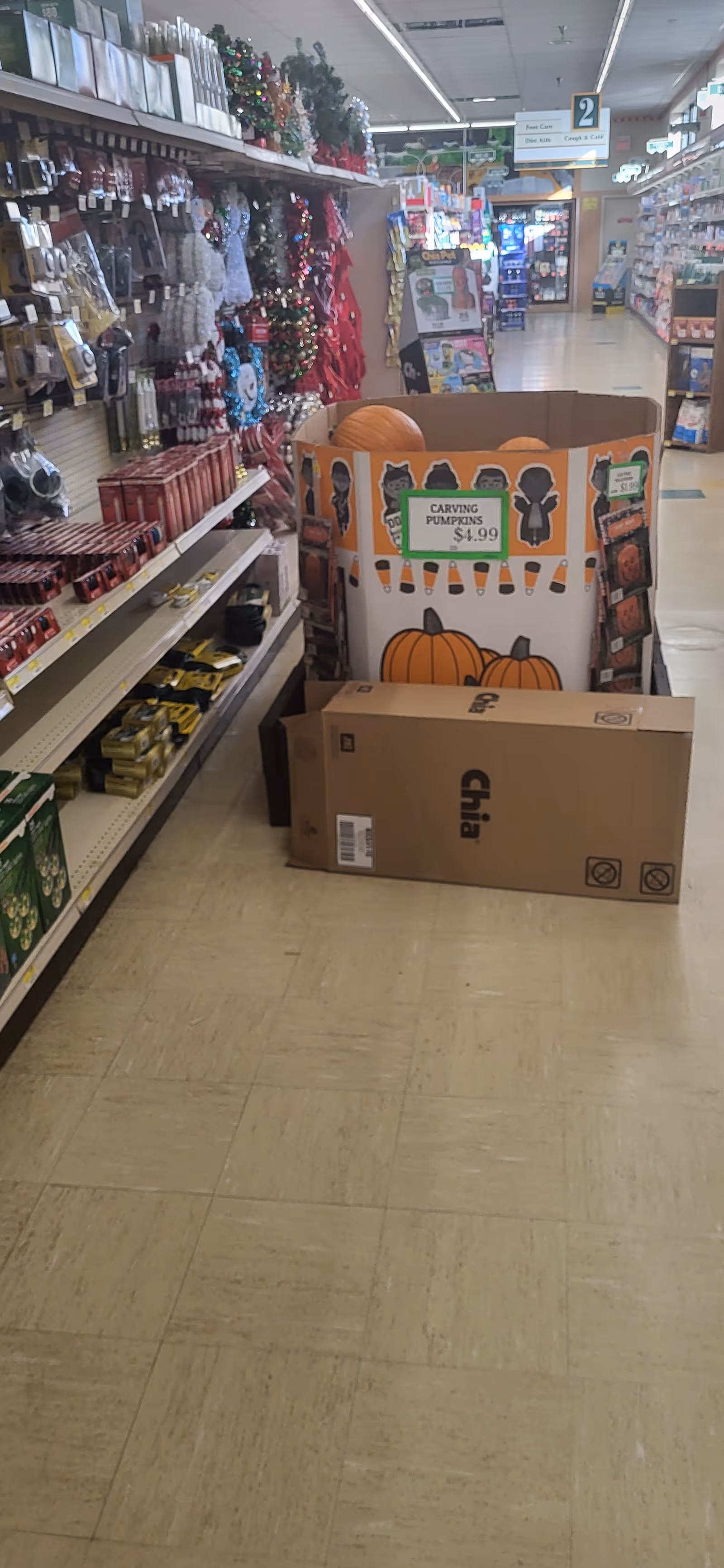 A Discount Drug Mart aisle with Halloween-themed pumpkin display and shelving along the left.