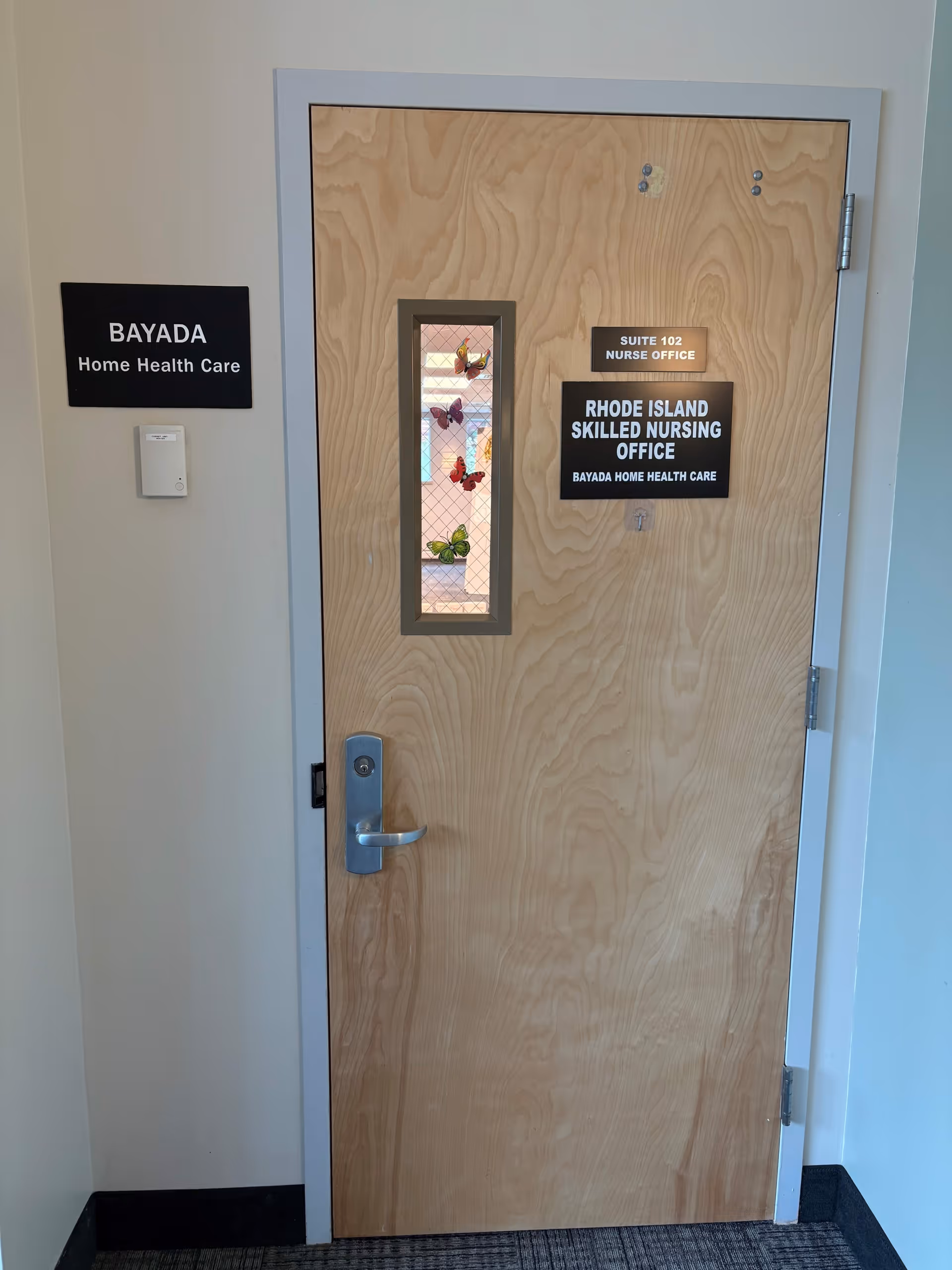 Interior hallway door with butterfly window and nurse office signs.