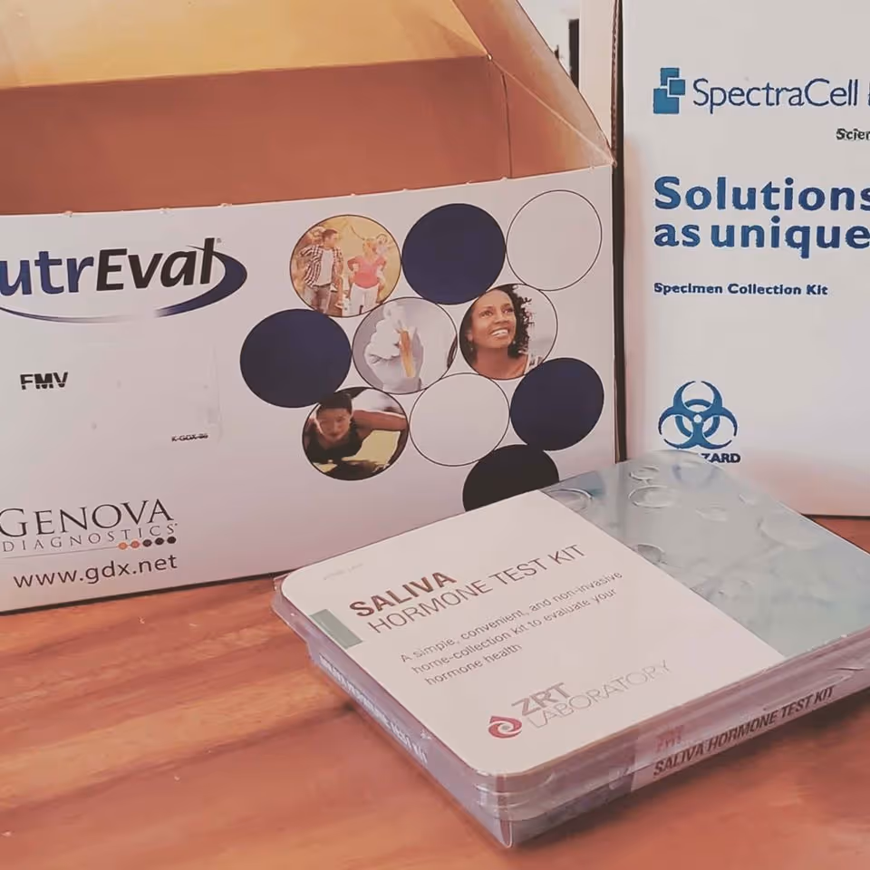 Boxes of saliva hormone test kits on a wooden desk in an interior setting