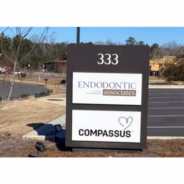 Tall black sign reading 333 with Endodontic Associates and Compassus in a parking lot.