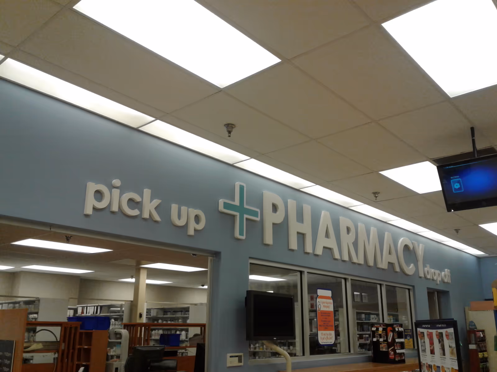 Interior of a Kroger Pharmacy featuring a large pickup sign and front counter.