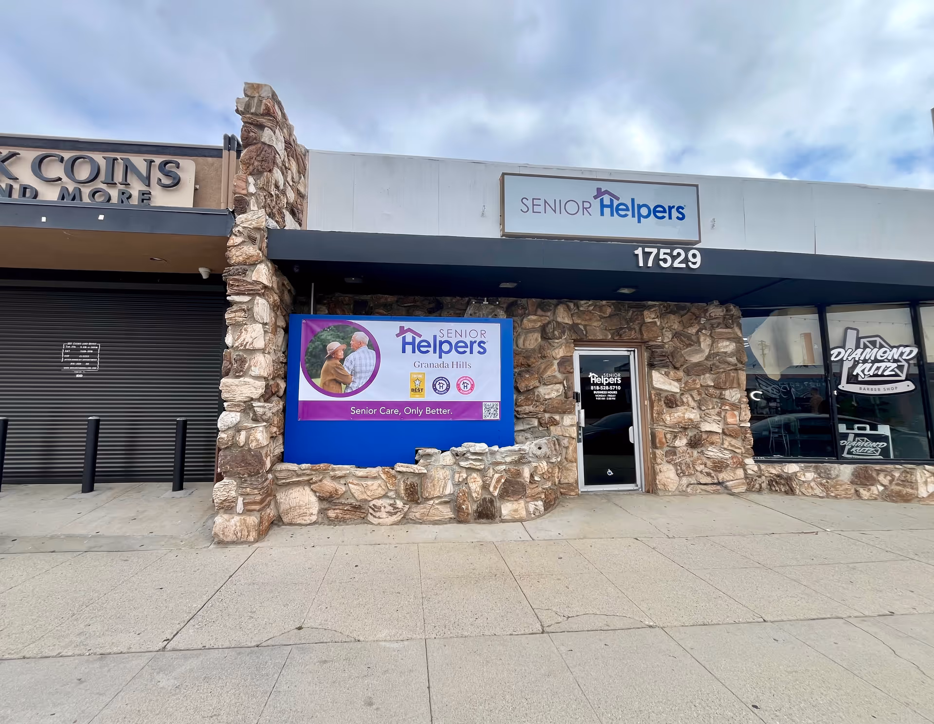 Stone front senior care storefront with Senior Helpers sign and promotional banner beside the entrance.