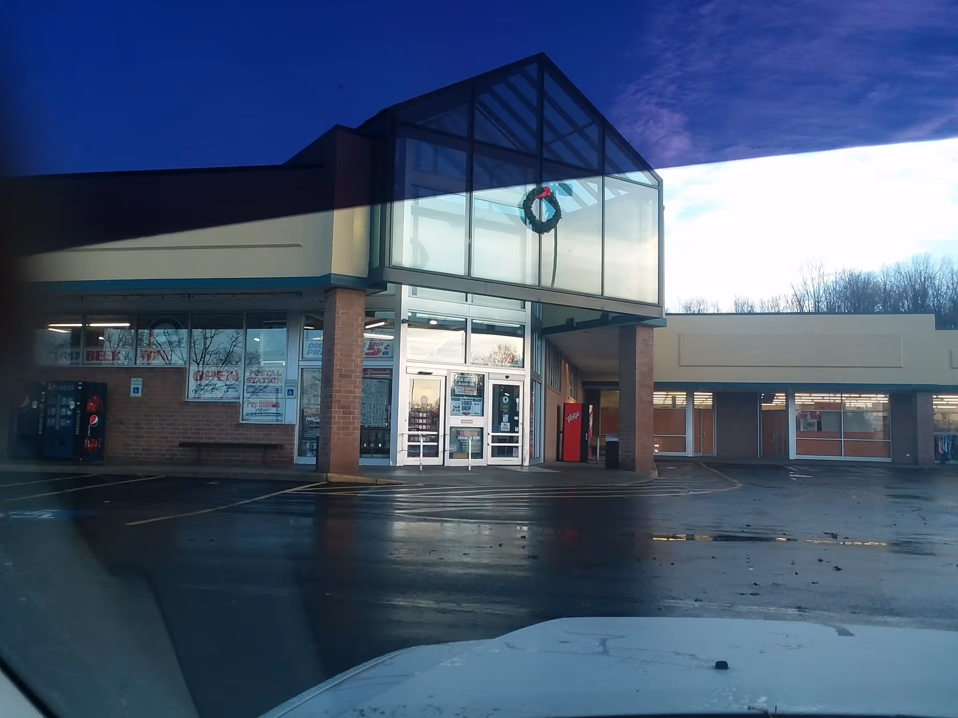 Discount Drug Mart storefront with glass entrance, wreath, and parking lot visible.