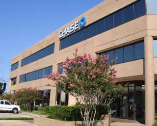 Exterior view of a Chase bank building with trees and landscaping in front.
