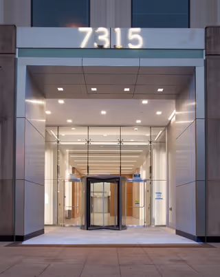 Building entrance at 7315 with glass doors and a bright, spacious lobby.
