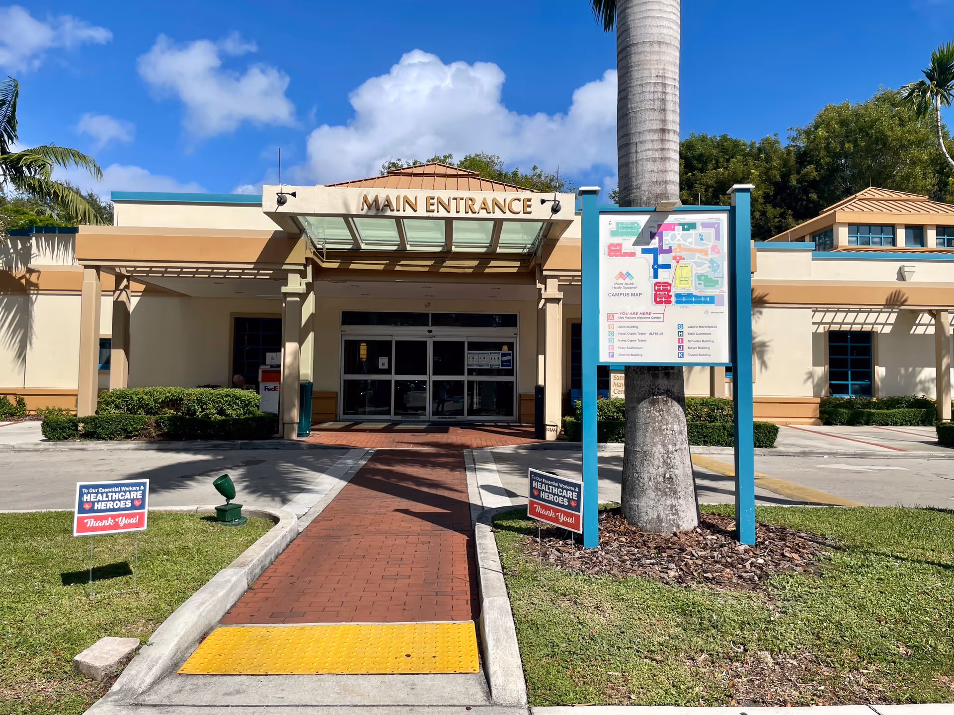 Front view of a senior living facility main entrance and map sign.