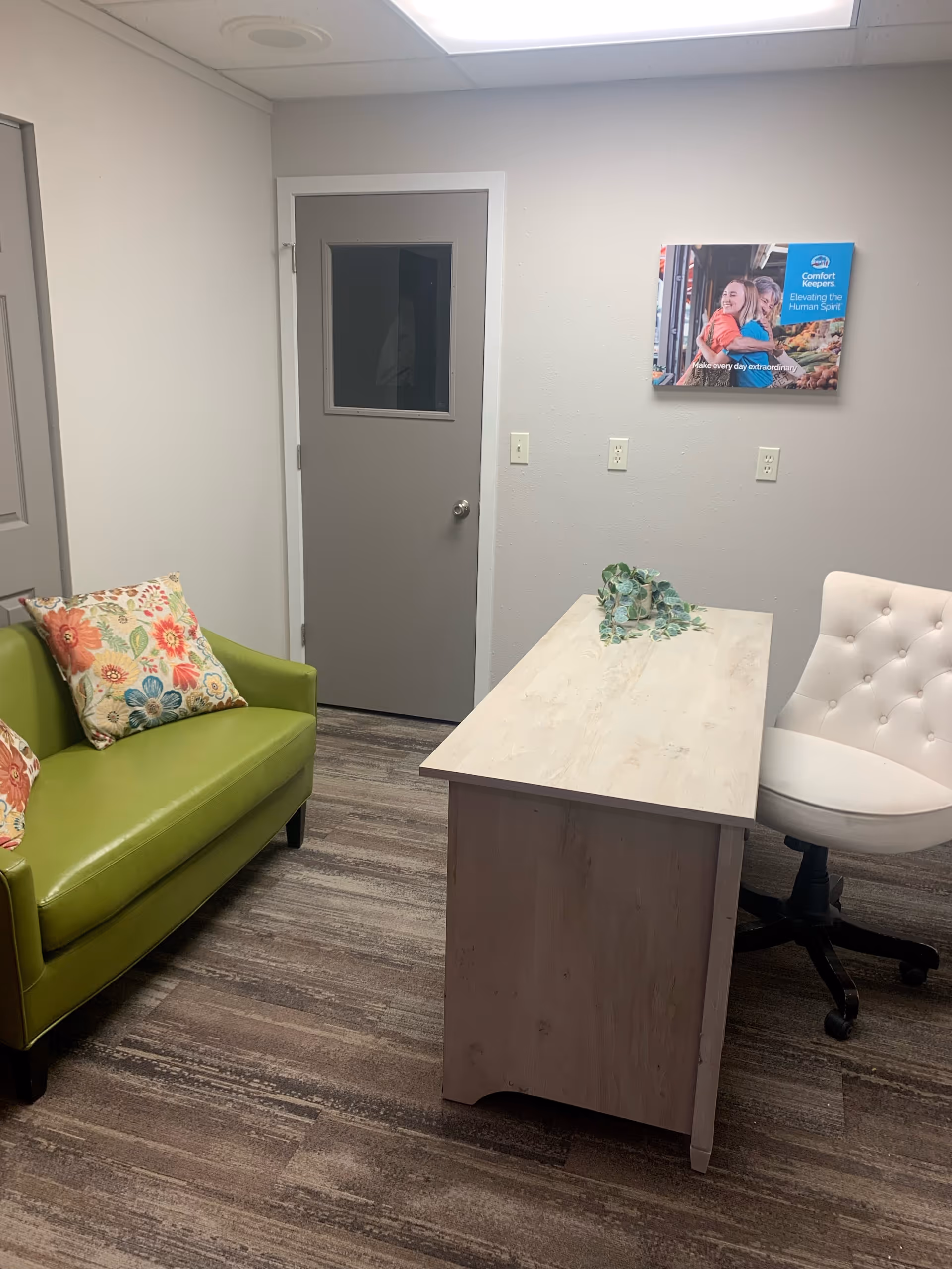 Small reception area with lime green couch, desk, and white chair.