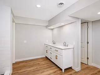 Bright, modern bathroom area with a double-sink vanity and light gray walls.