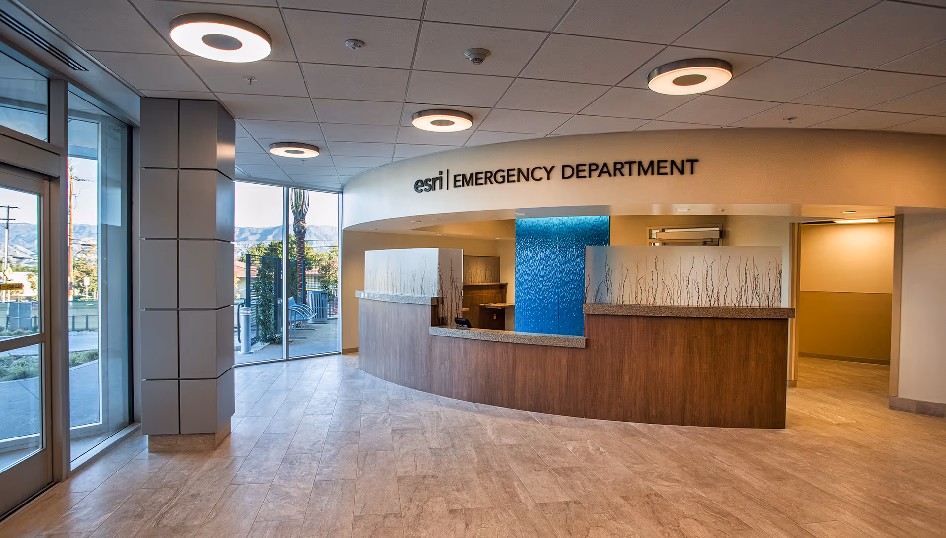 Interior view of Redlands Community Hospital emergency department with curved wood reception desk.