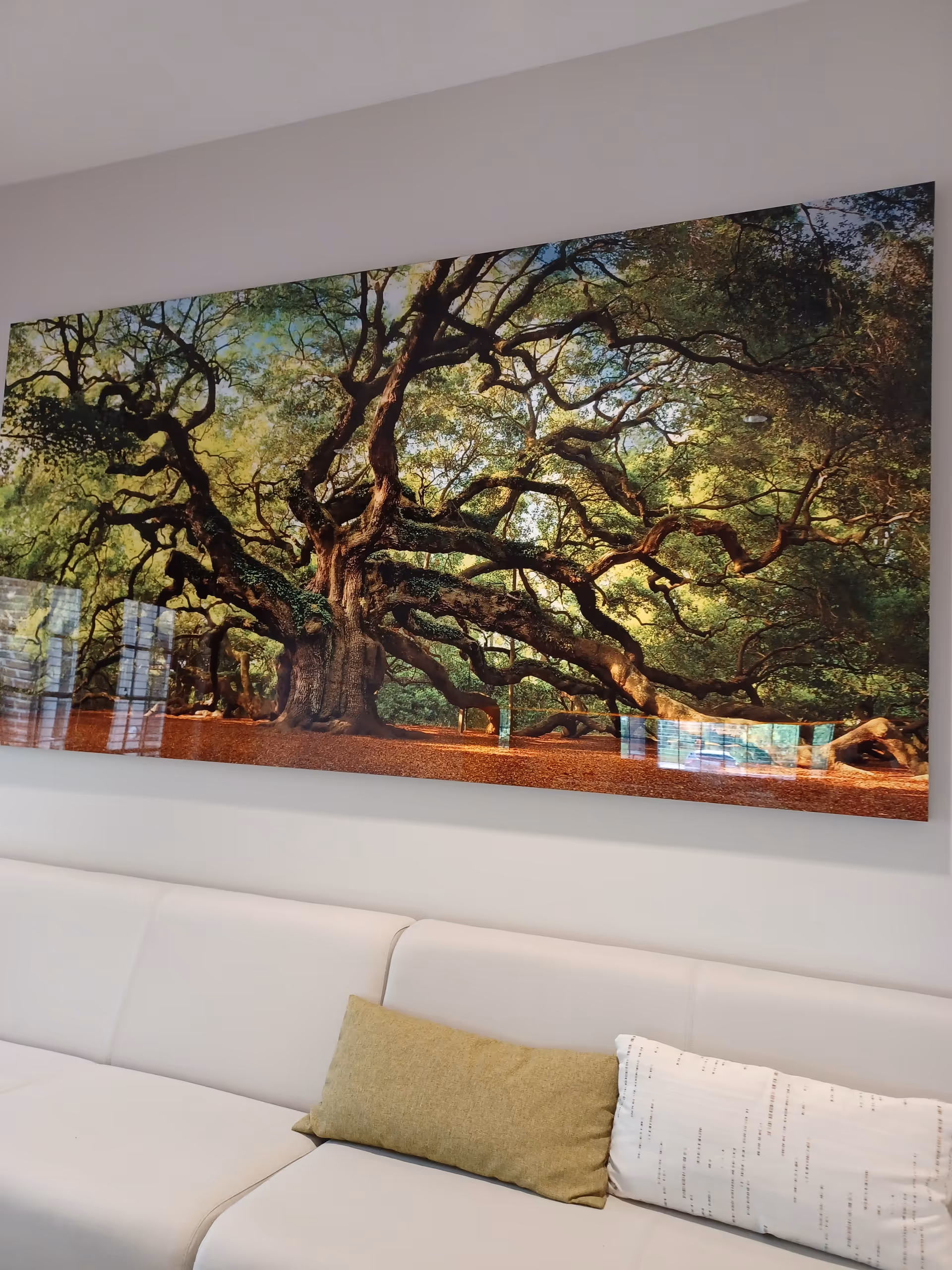 Large tree mural hangs above a white sofa in a modern living room.