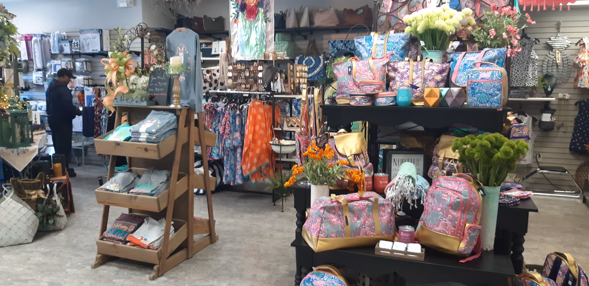 Interior Commonwealth Home Health Care gift shop with colorful bags, clothing, and decor.