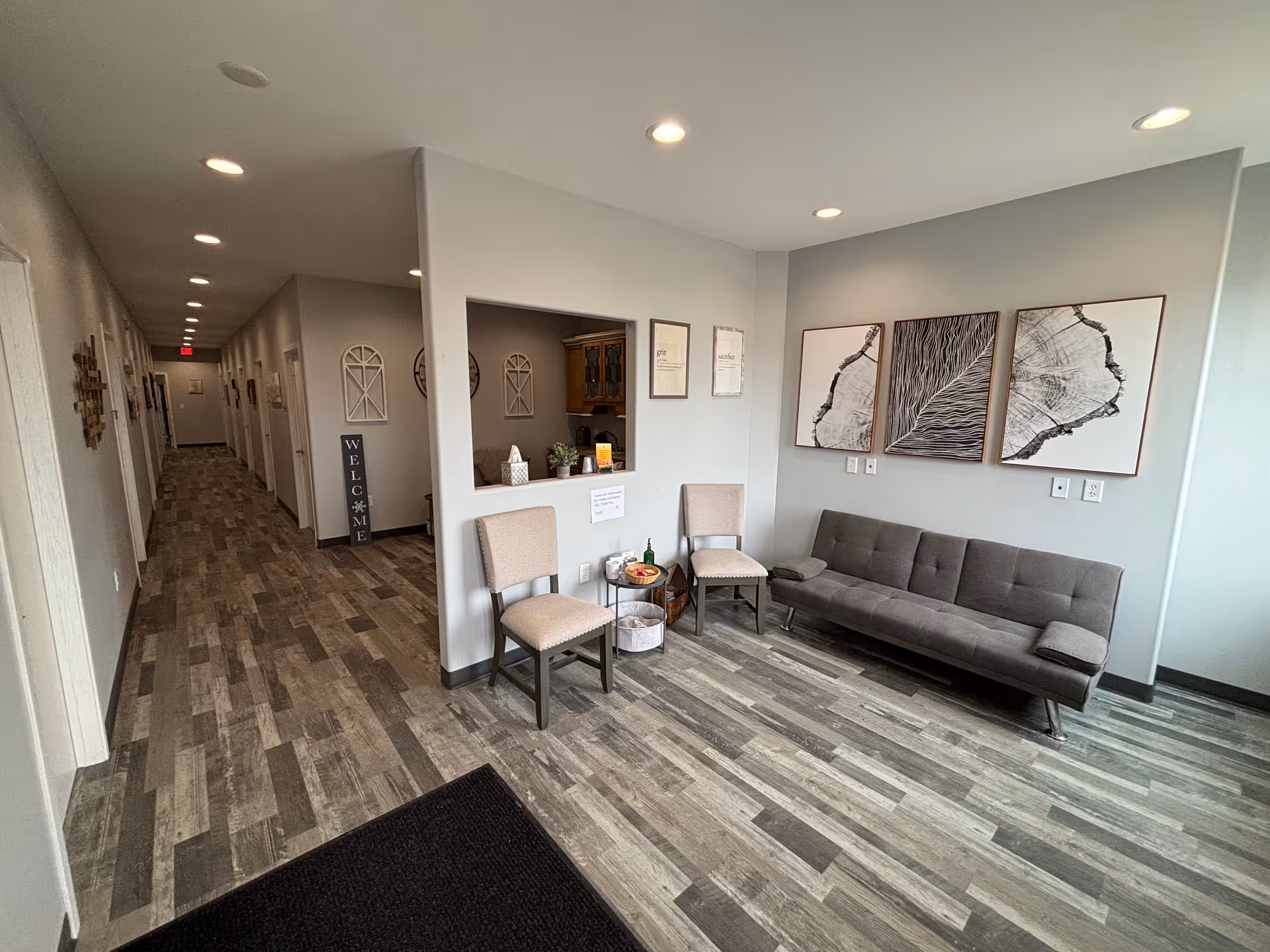 Long, well-lit hallway with seating area and modern decor in a senior living facility.