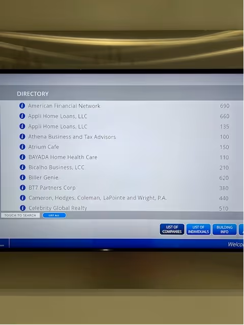 Indoor directory screen displaying company listings in a BAYADA facility lobby.