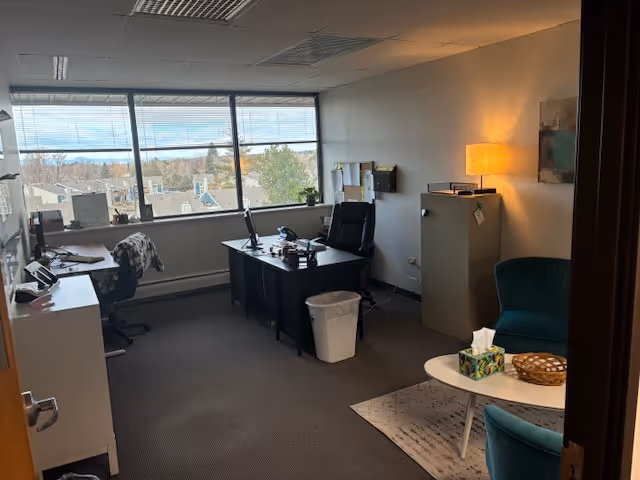Office workspace inside a senior care facility with desks, chairs, and a window view.
