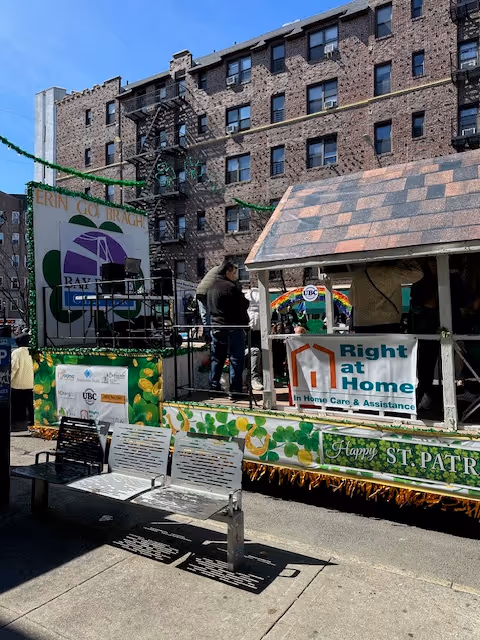 Outdoor parade float for Right at Home with staff and banners on a city street.