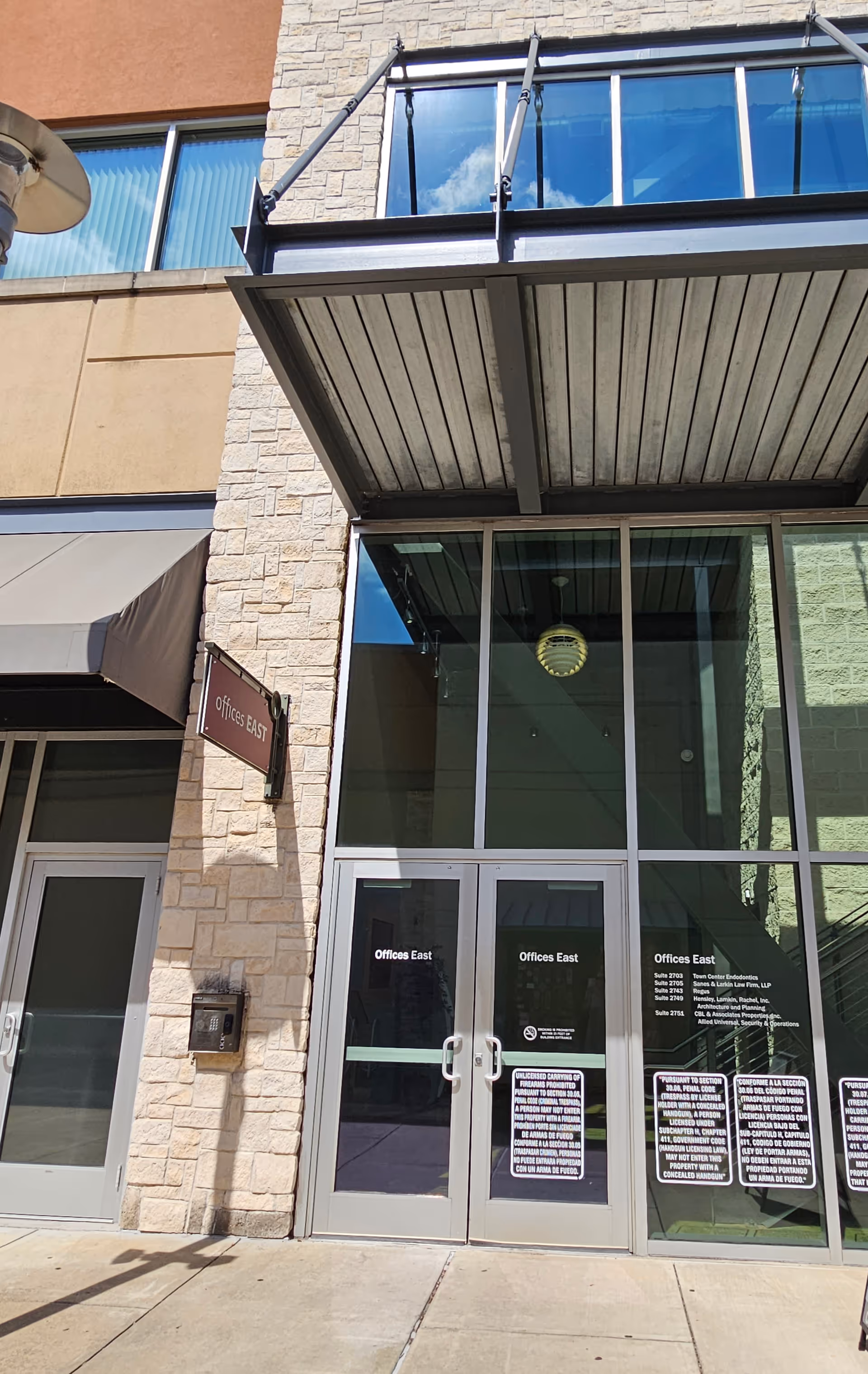 Modern building exterior featuring glass entrance doors labeled Offices East.