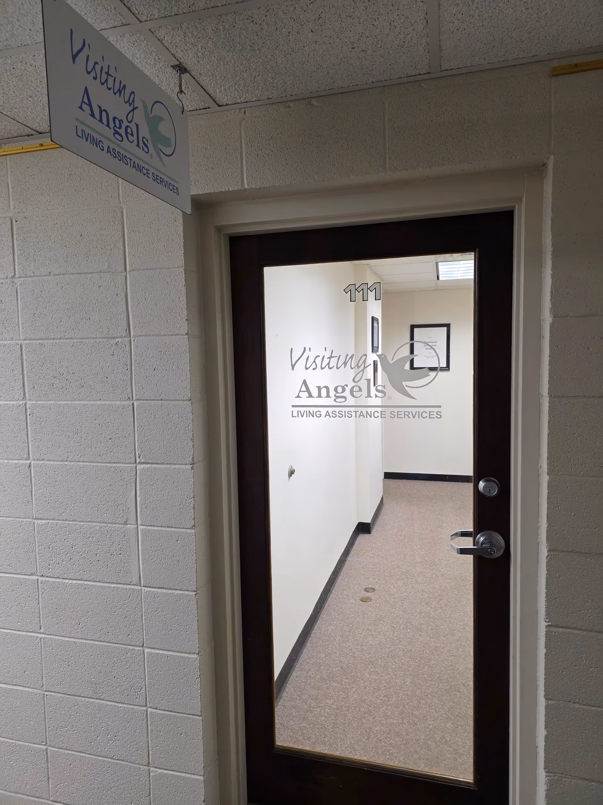 Interior hallway of Visiting Angels facility with doorway labeled 111.