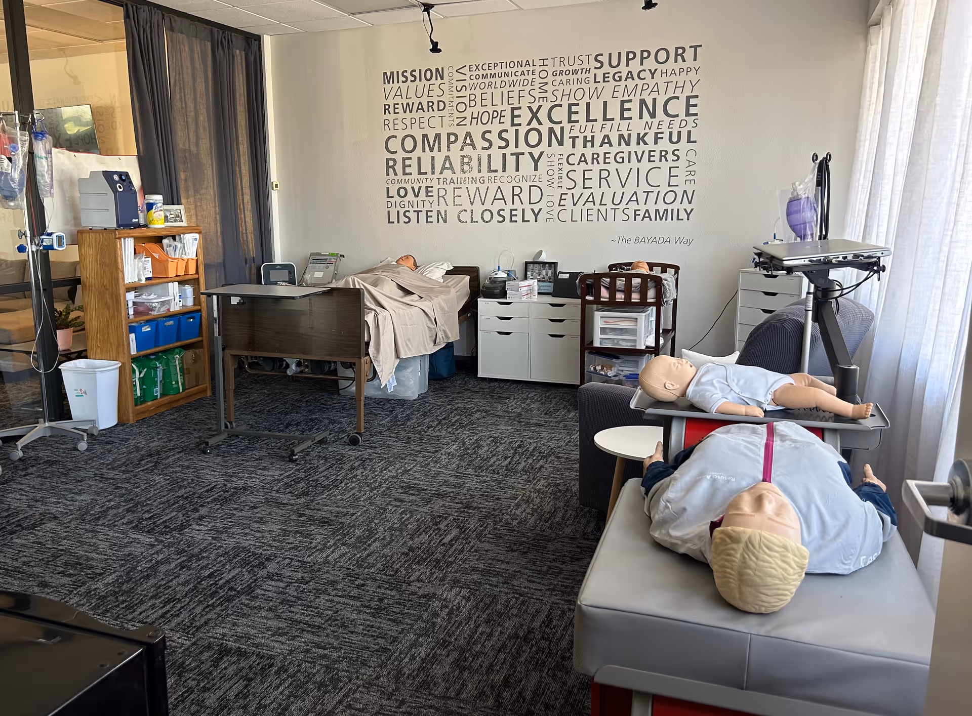 A clinical training room with medical mannequins, beds, and medical equipment.
