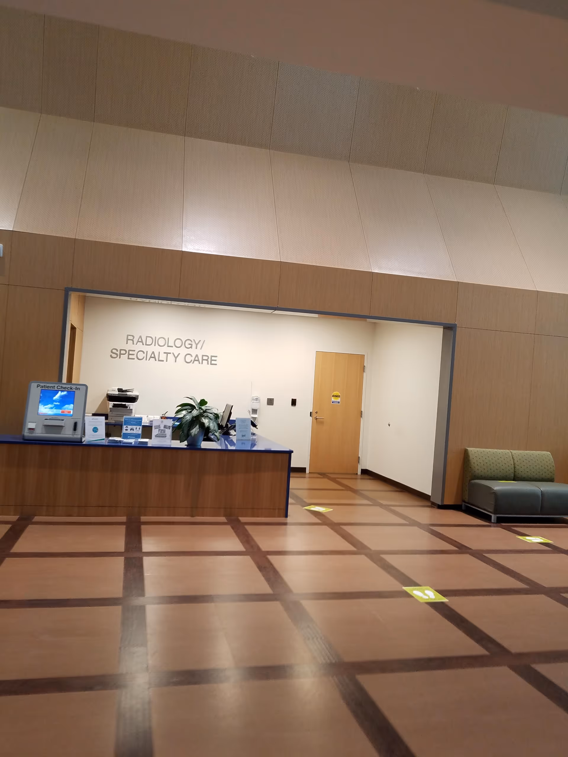 Reception desk in a hospital lobby with Radiology/Specialty Care signage.
