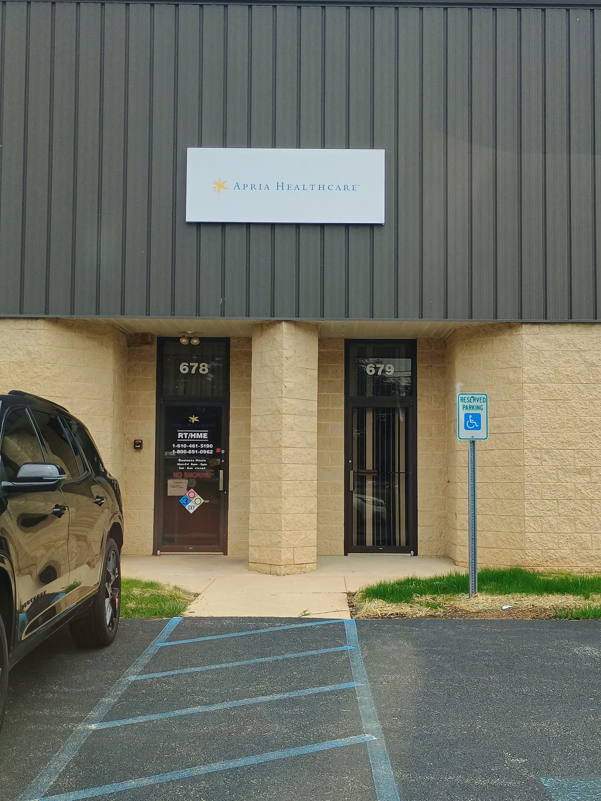 Exterior view of Apria Healthcare building front with two entry doors and parking.