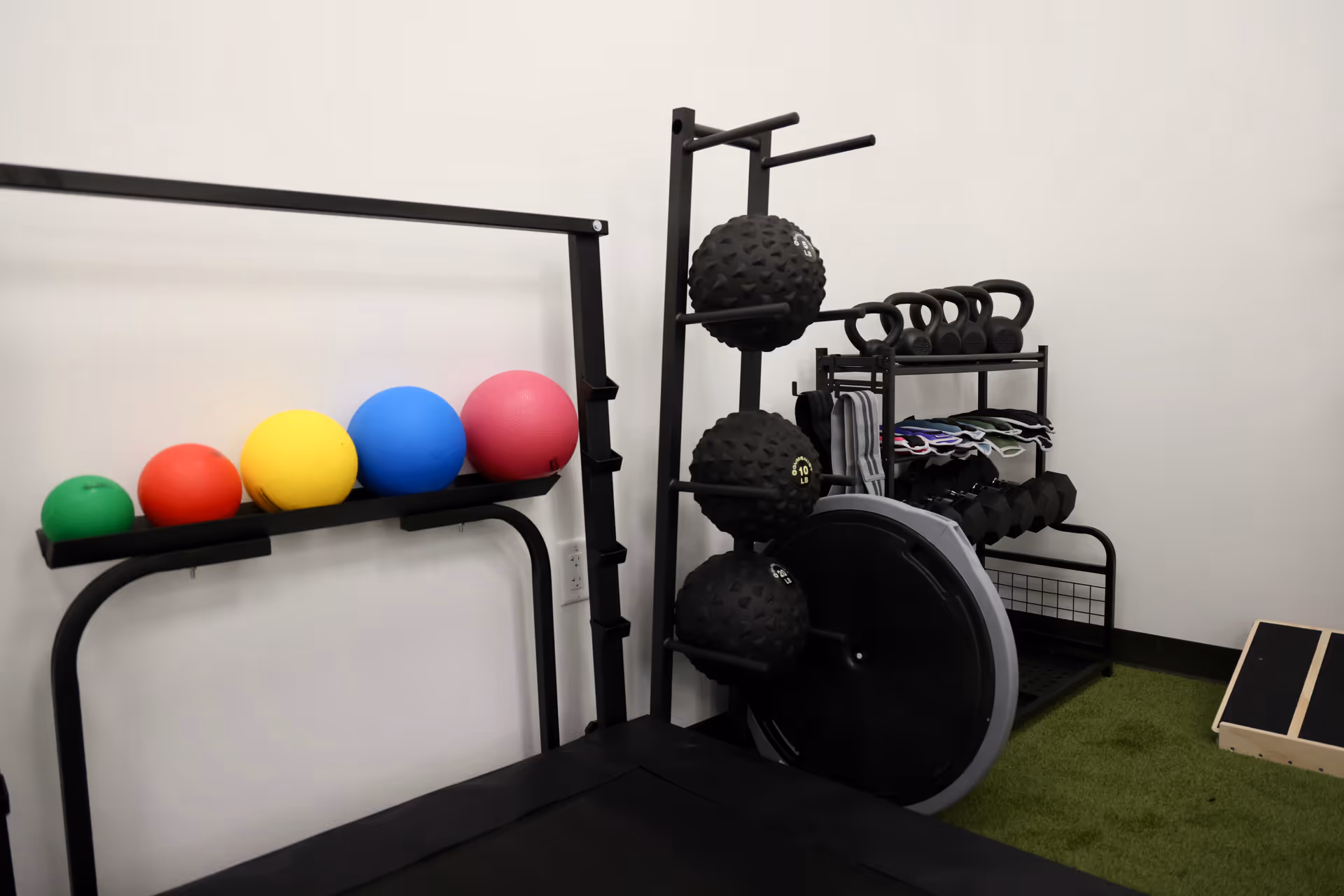 A rehab gym area with medicine balls, weights, and exercise equipment.