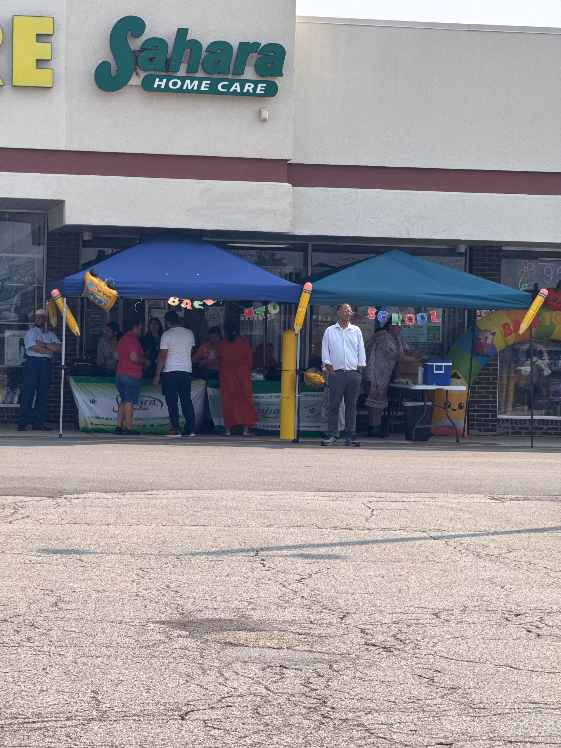 Sahara Home Care storefront with blue tents and people gathered outside.