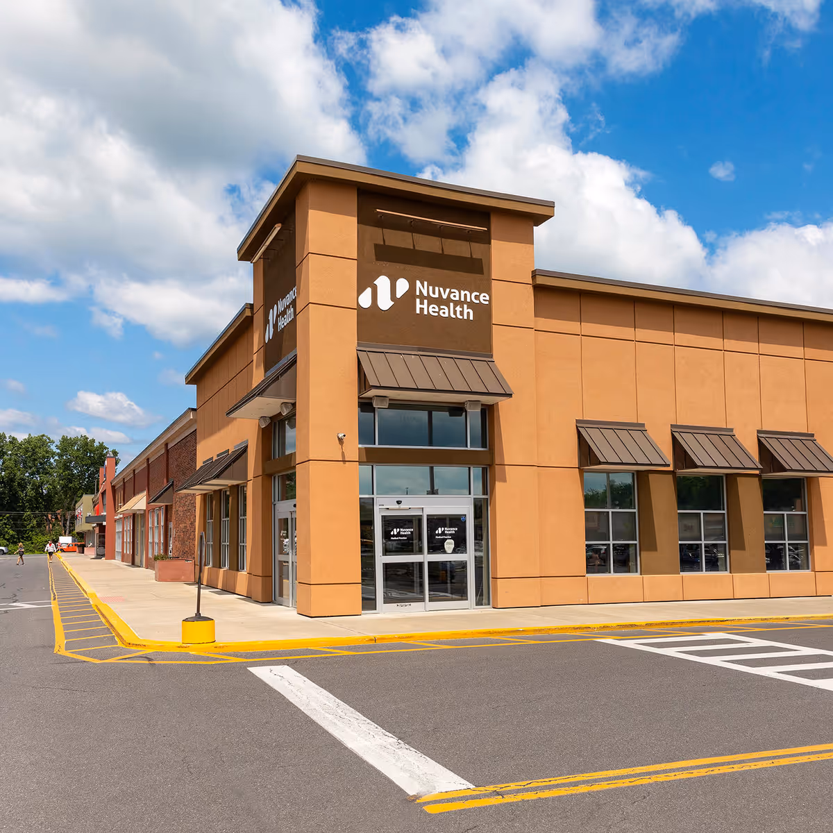 Orange-toned medical clinic exterior with Nuvance Health sign and glass entry doors.