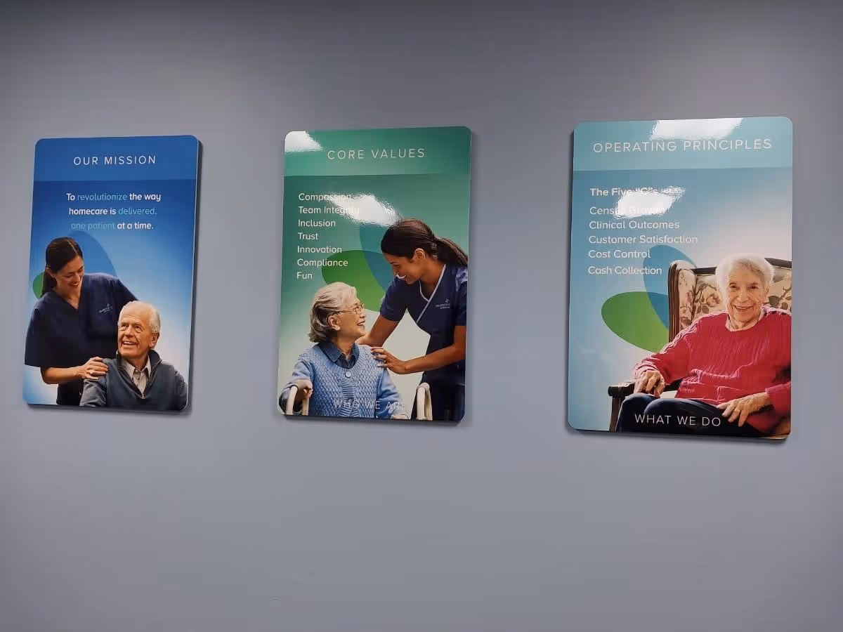 Interior wall with three large posters displaying mission, core values, and operating principles.
