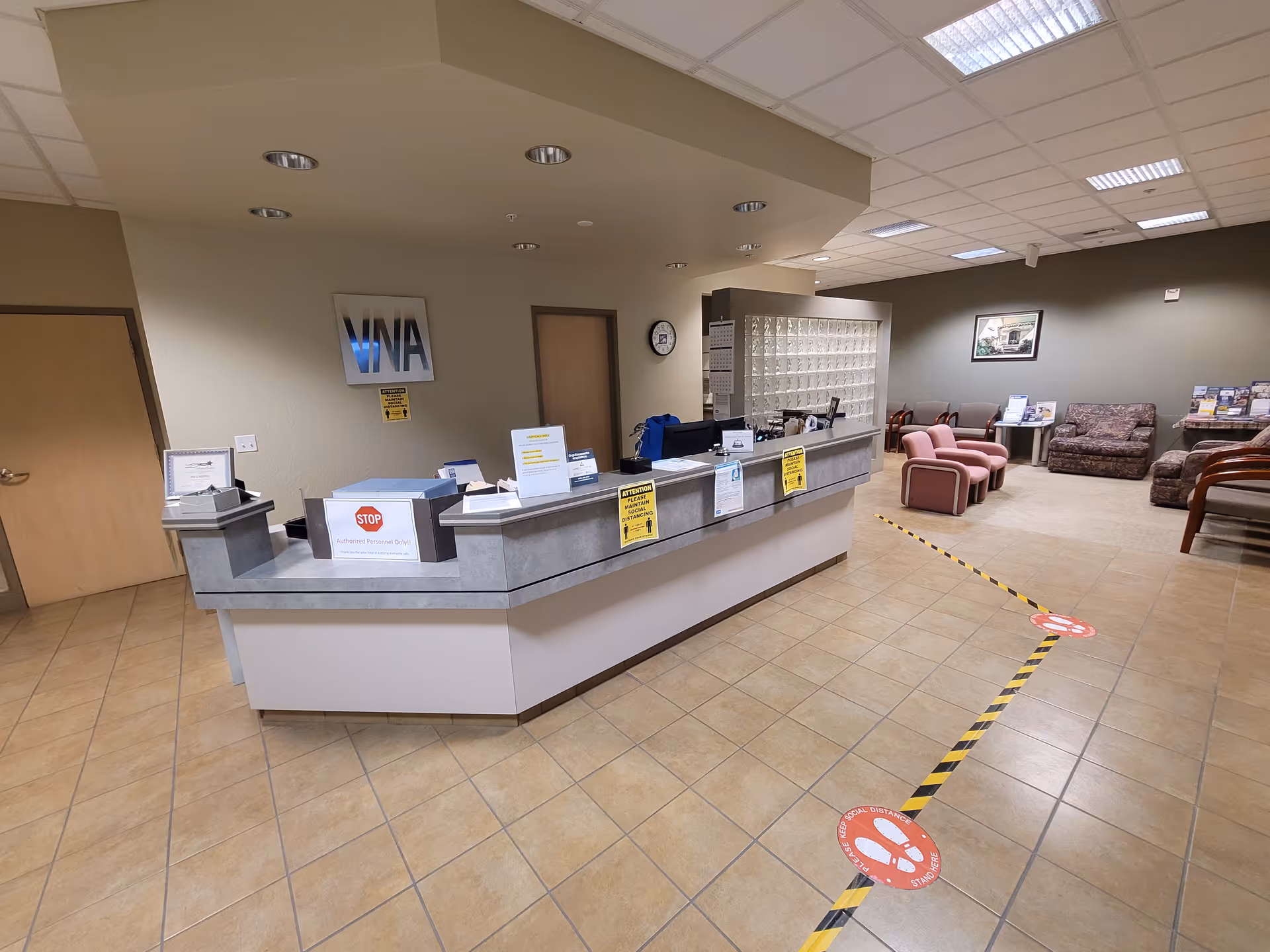 A spacious interior lobby with a curved reception desk, mailboxes, and seating area.