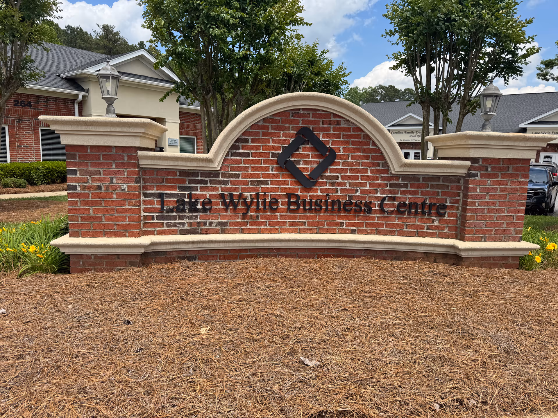 Brick entrance sign reading Lake Wylie Business Centre with surrounding landscaping