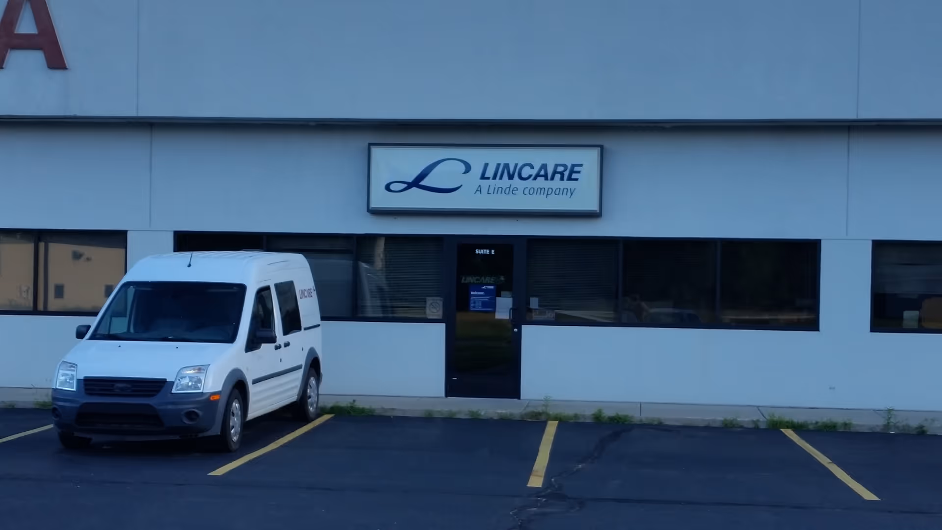 Exterior view of a LINCARE building with a white van parked in front.