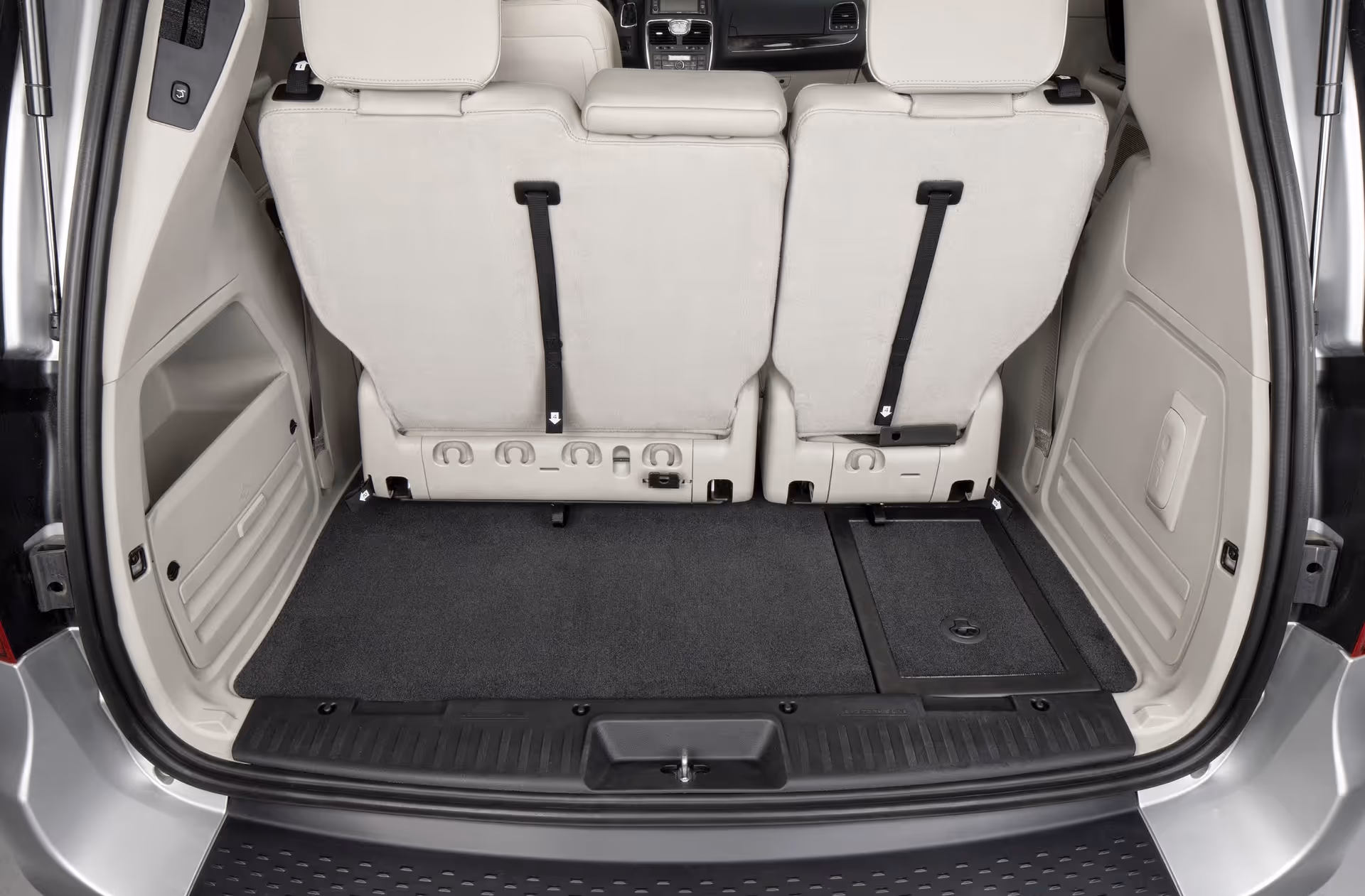 Rear view of a minivan interior with folded second-row seats and cargo space.