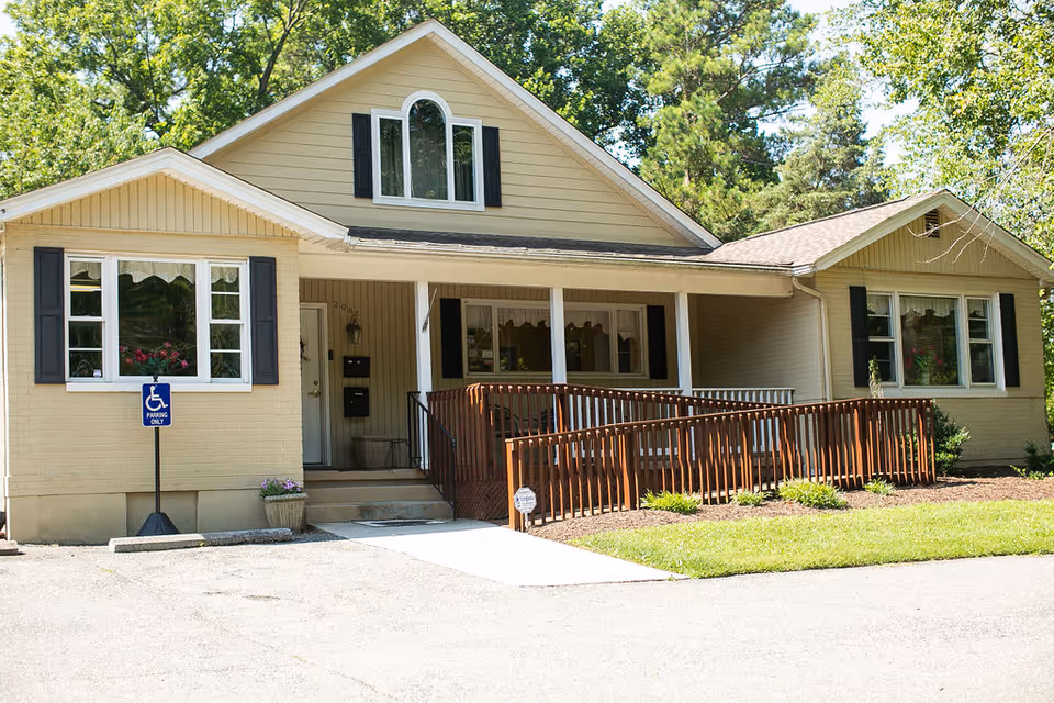Exterior of a beige, single-story senior living facility with a ramped porch.