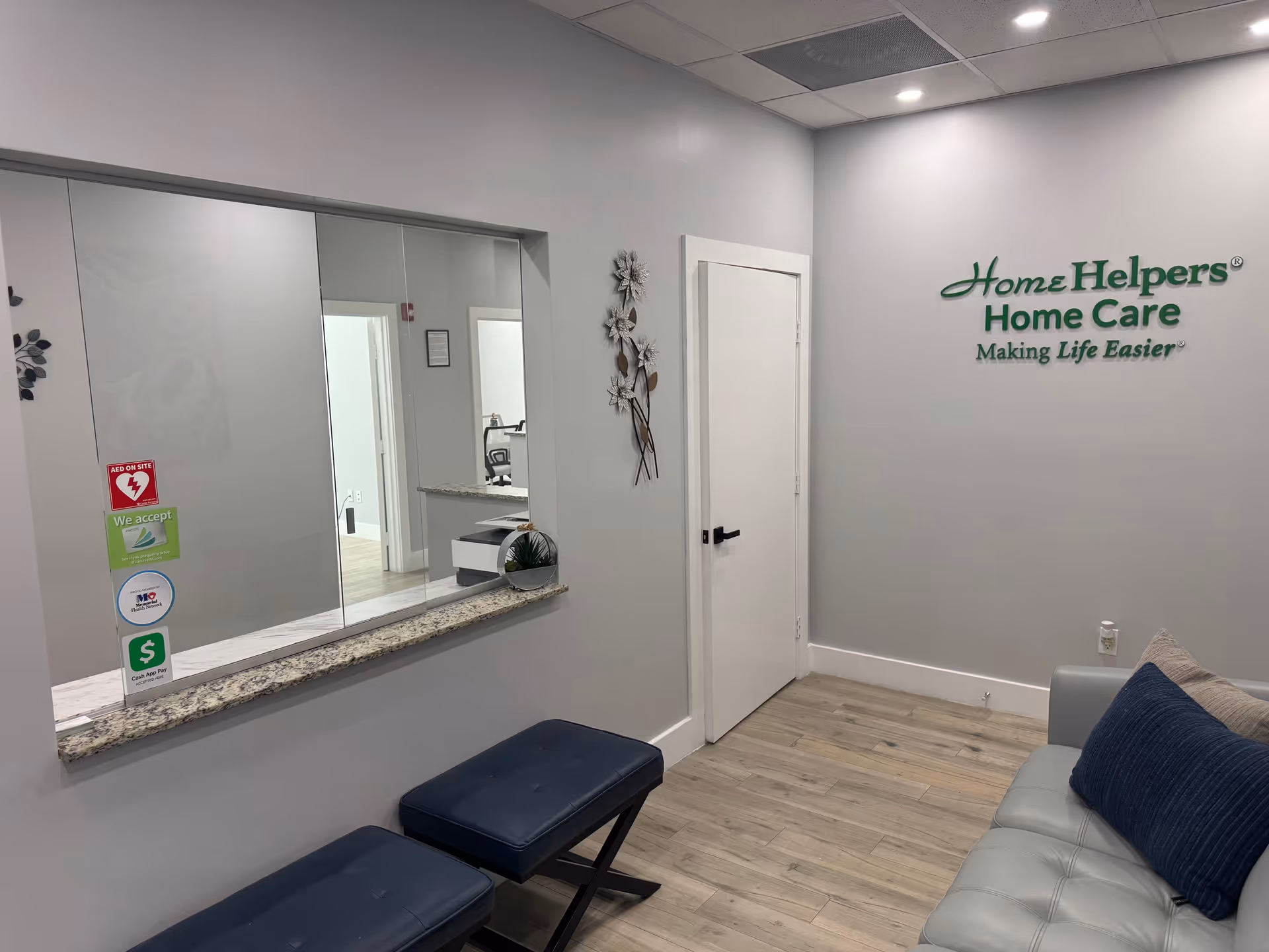 Interior lobby of Home Helpers Home Care with a reception window and seating.