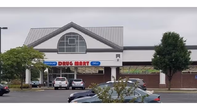 Discount Drug Mart storefront with parking lot and trees in front.