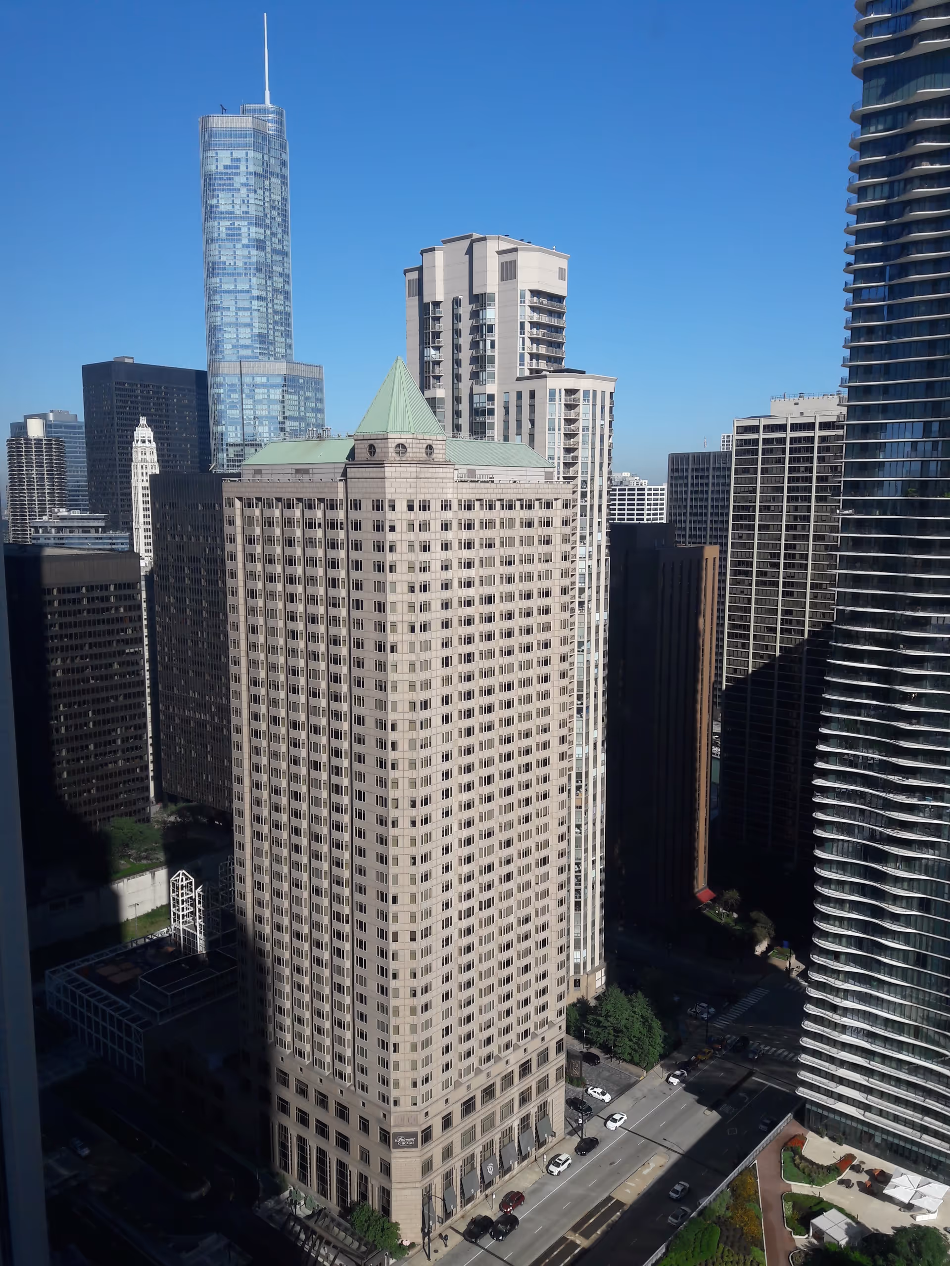 Tall city skyscrapers with a beige high-rise building and surrounding modern towers.