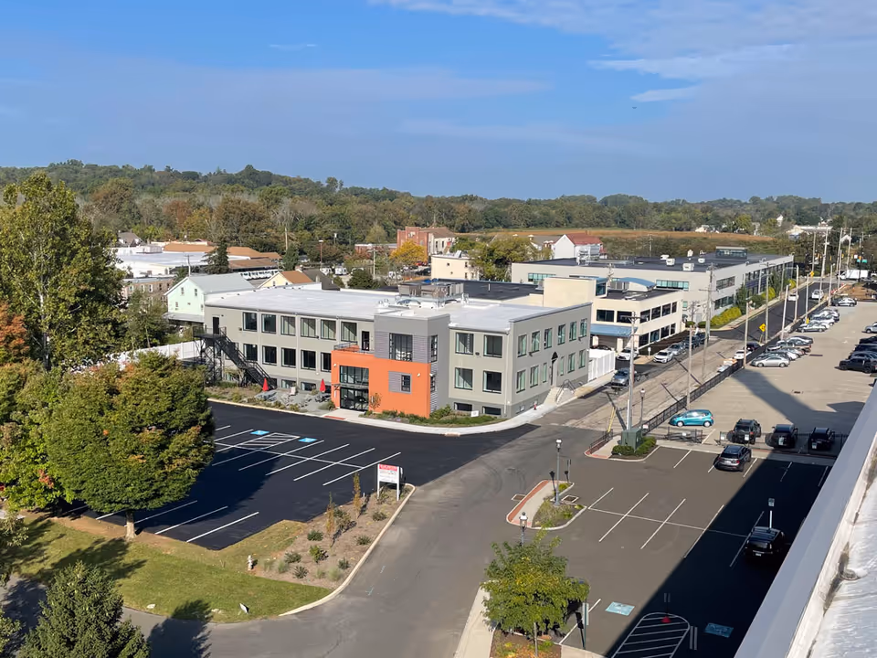 Aerial view of a modern senior care campus with multiple buildings and an expansive parking lot.