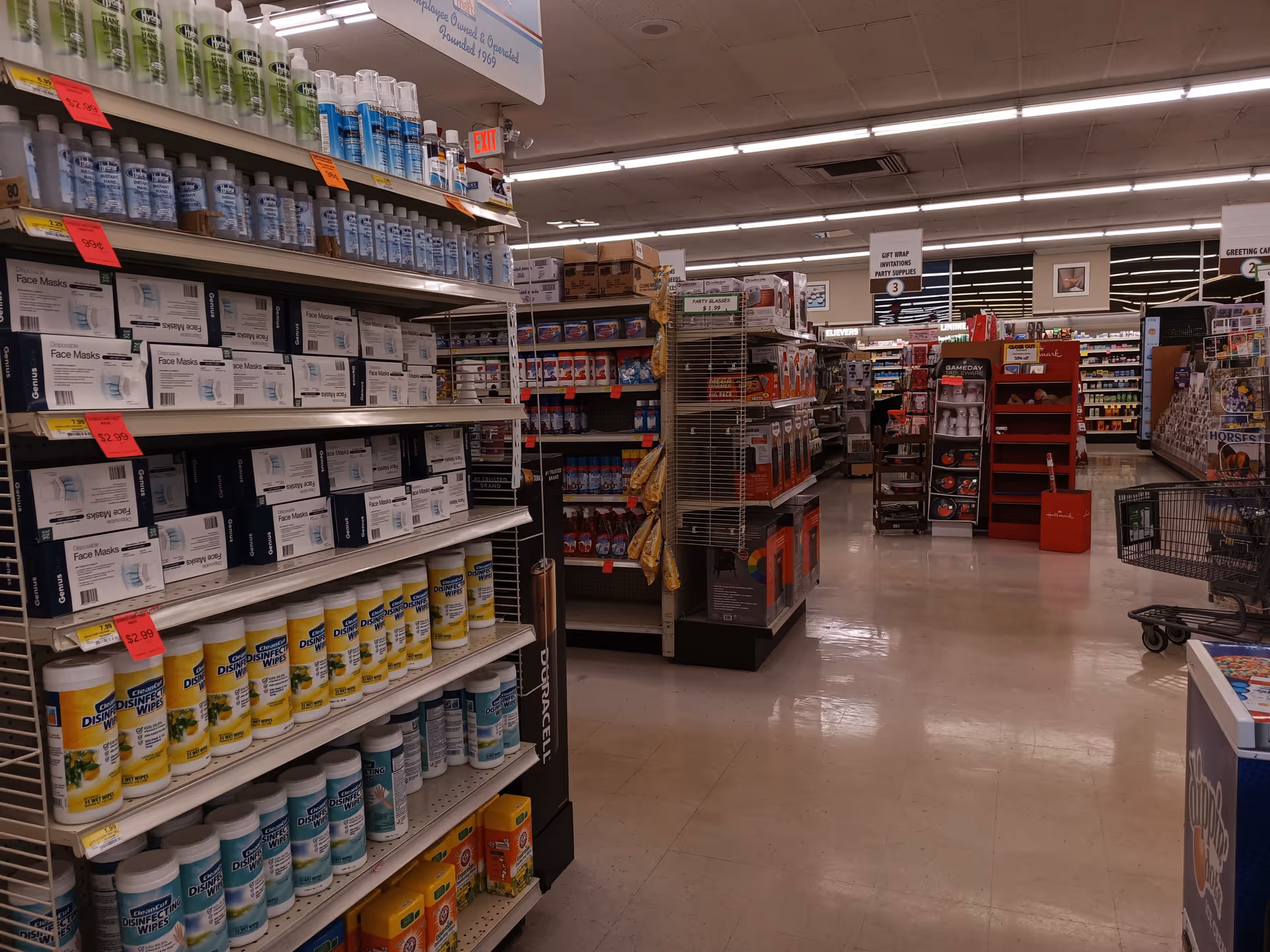Aisles of Discount Drug Mart store with shelves, shopping carts, and bright lighting.