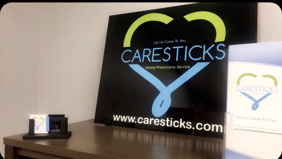 Interior desk area featuring a large CareSticks sign and supporting business cards on a small stand.