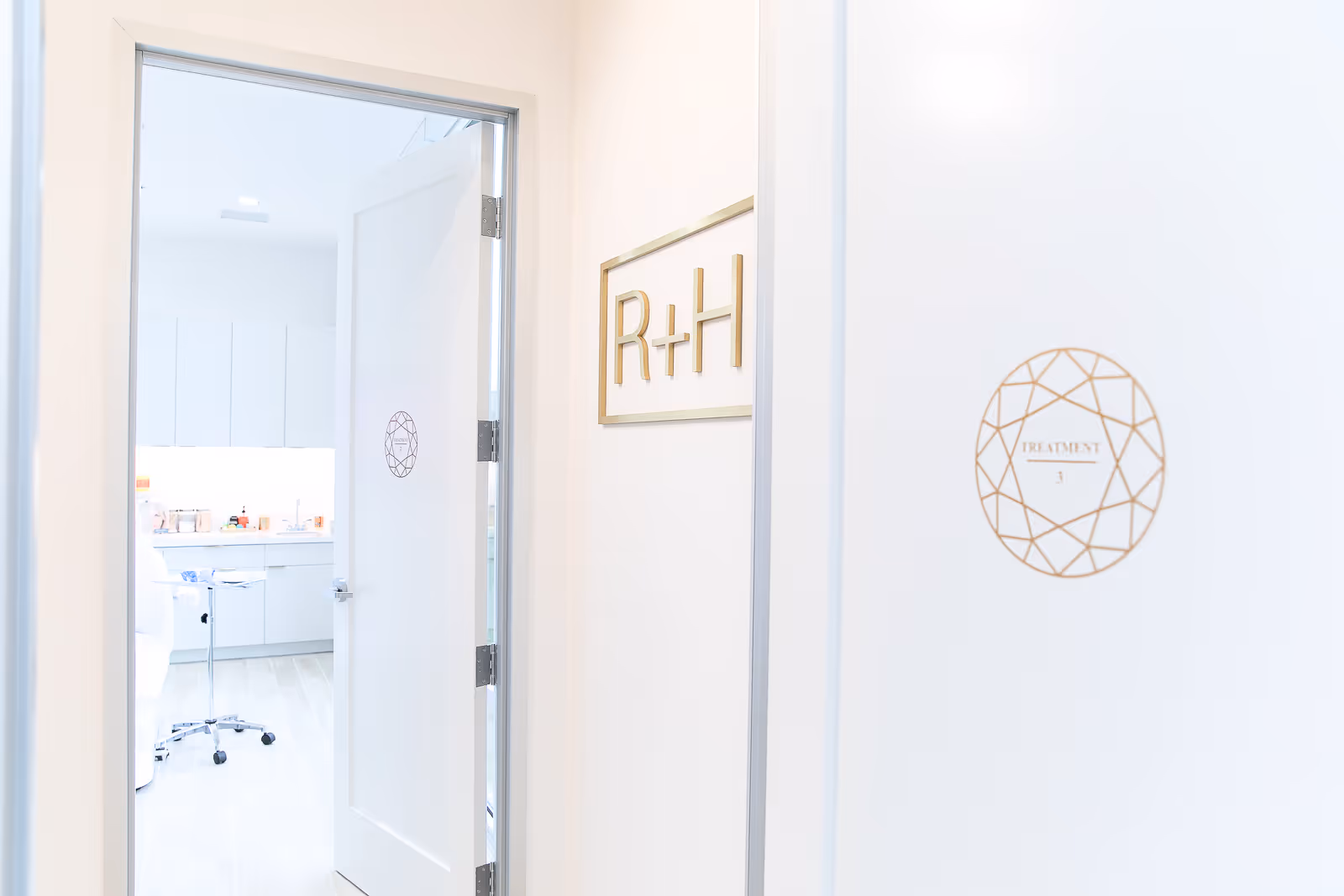 Bright corridor with a door labeled R+H and a visible treatment room interior.